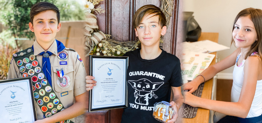 A boy in a scout uniform holds awards and ribbons. Another boy in a Quarantine t-shirt holds a certificate and cookies. A girl sitting at a table smiles, surrounded by papers. They are indoors, with a door and table visible.
