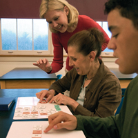 Teacher using letter tiles with two adults