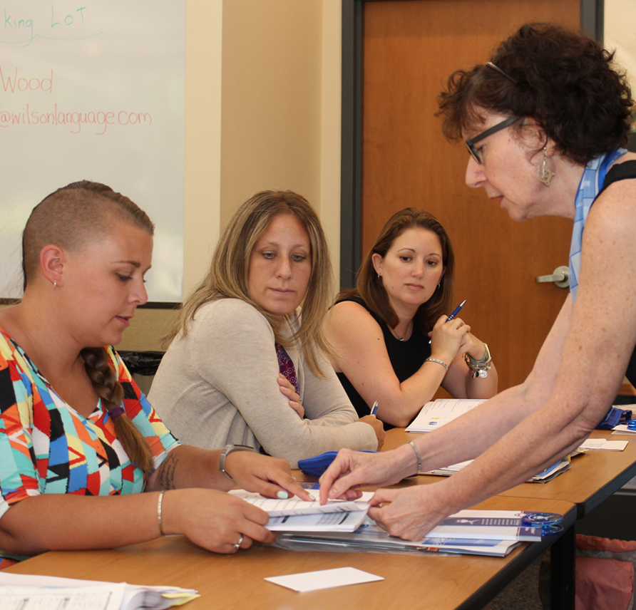 Workshop instructor pointing to participant's hand out booklet.