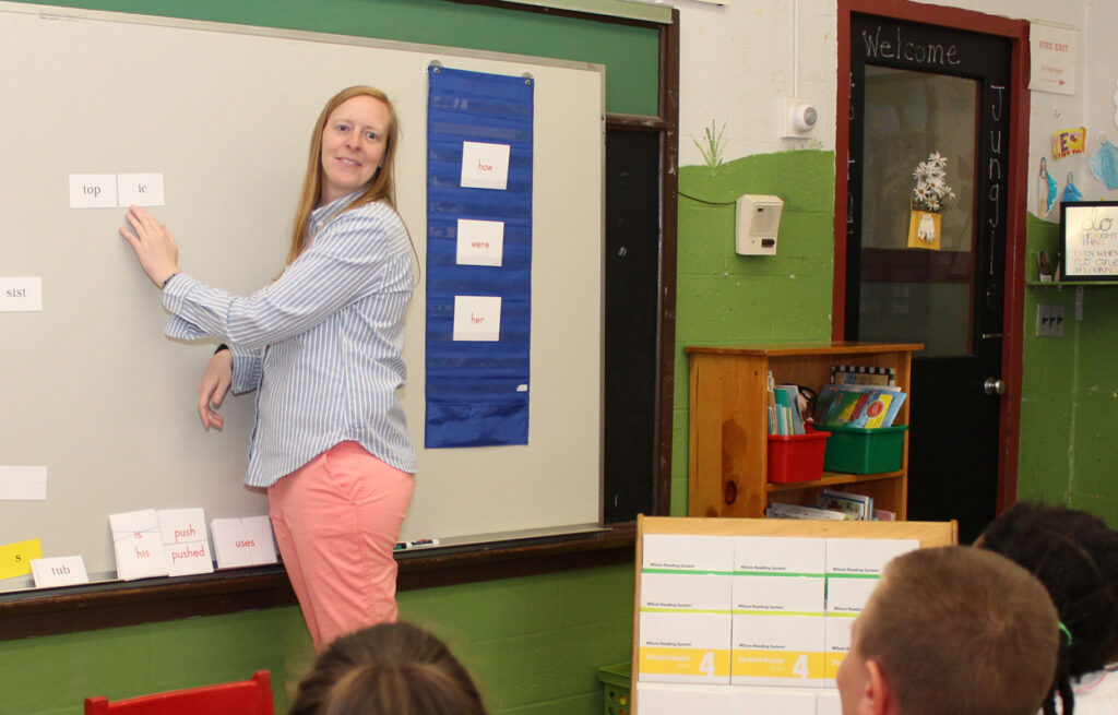 WRS teacher pointing at word on white board