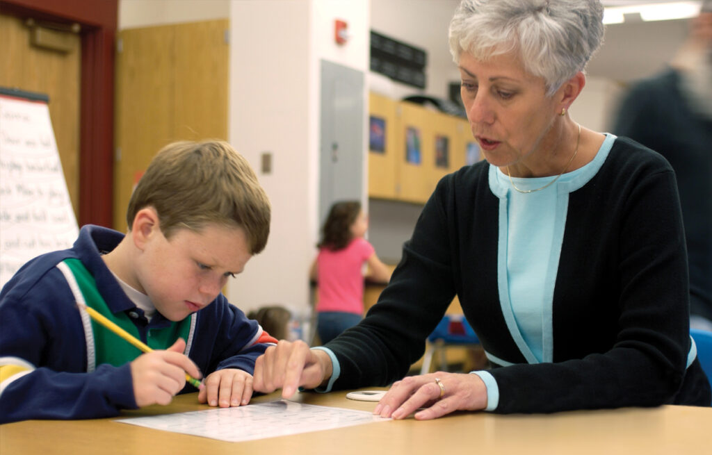 Teacher pointing to a paper in front of student