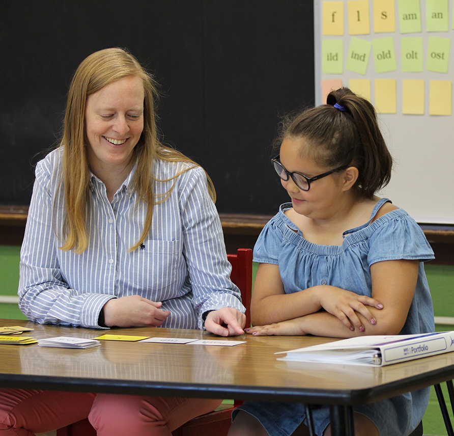 WRS teacher sitting with her student and pointing at syllable frames