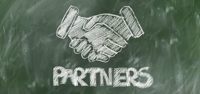 chalkboard drawing of shaking hands above the word Partners