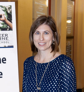 Beth Horner_CC Beth Horner wearing a blue blouse and smiling at the camera.