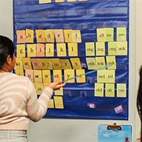 Student pointing to letter cards using a pointer stick.