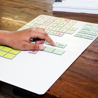 A person moving magnetic letter tiles on a magnet board.