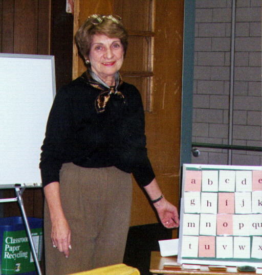 Maxine Goldman standing next to Wilson Reading System letter cards