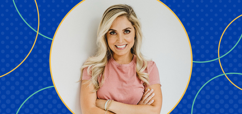 Smiling person with long blonde hair and a light pink shirt stands with arms crossed against a light colored background. The image has a blue circular border with yellow and green accents.
