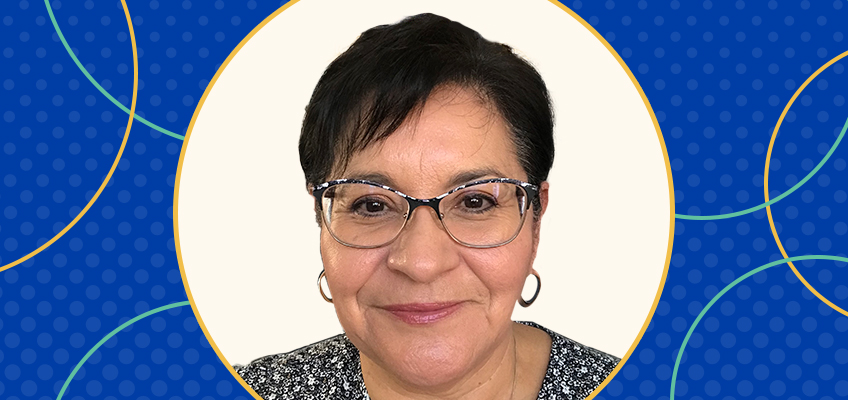 Woman with short dark hair, wearing glasses and hoop earrings, smiling at the camera. She is in front of a neutral background, surrounded by a graphic blue border with circular patterns.