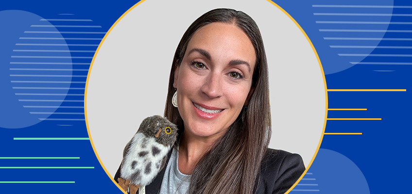 A woman with long dark hair smiles while holding a small bird on her shoulder. The background is a blue design with circles and lines.