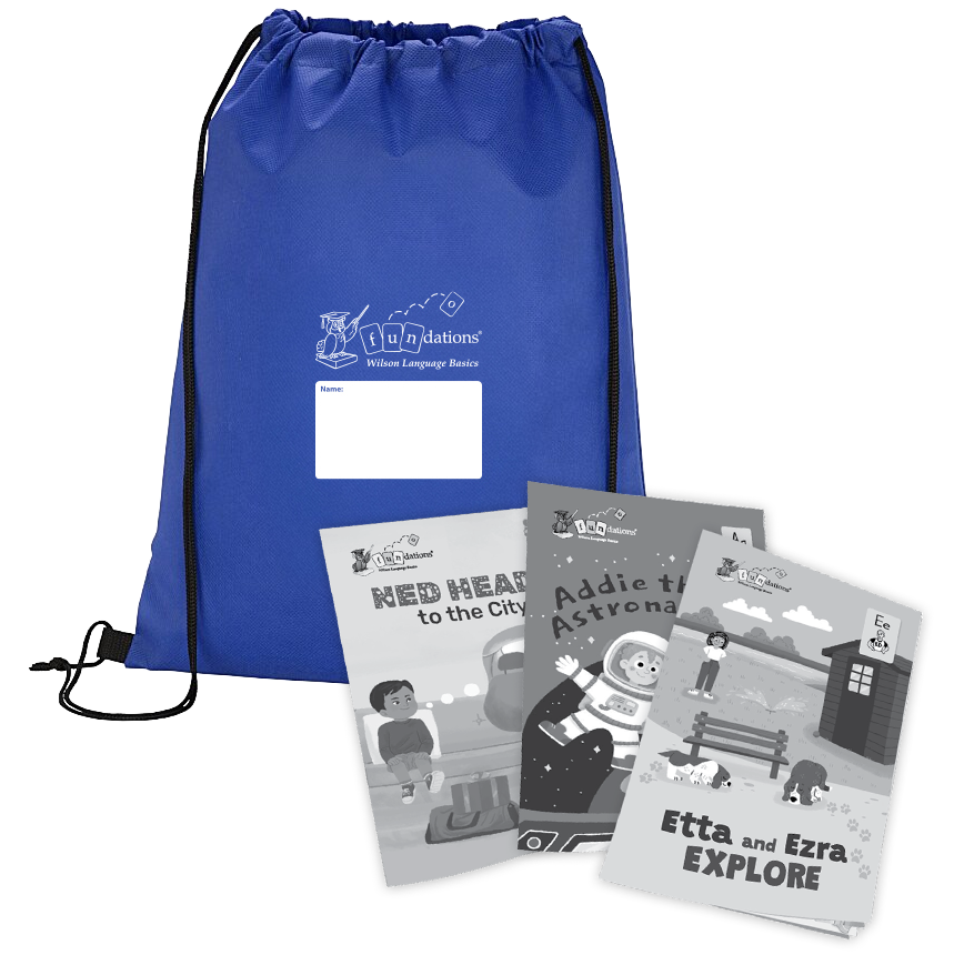 A royal blue Fundations® drawstring backpack with black cords and a white label for writing a name, shown alongside three illustrated children’s readers titled Ned Heads to the City, Addie the Astronaut, and Etta and Ezra Explore. The books are spread in front of the backpack and display black-and-white cover illustrations.