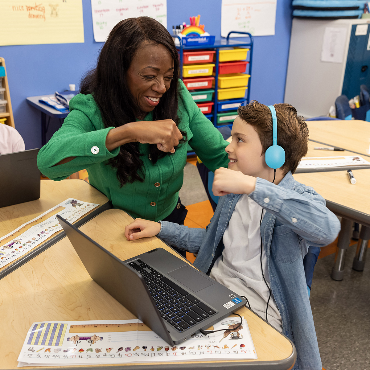 A teacher giving a student a fist bump