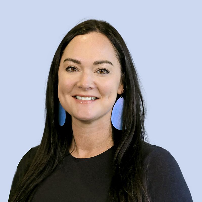Makenzie Buhman smiling at camera and wearing blue earings and a black top