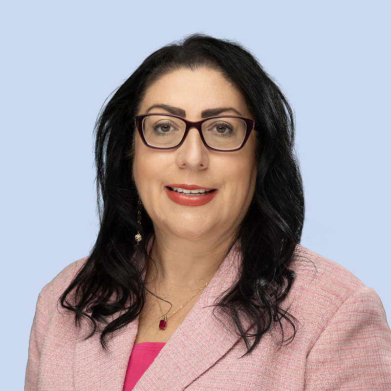 Misty Castillo smiling at camera and wearing a pink shirt and pink blazer