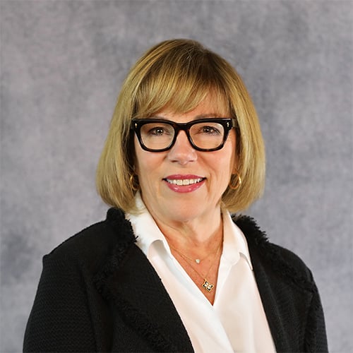 Portrait of woman with blonde bob and glasses, discussing structured literacy.