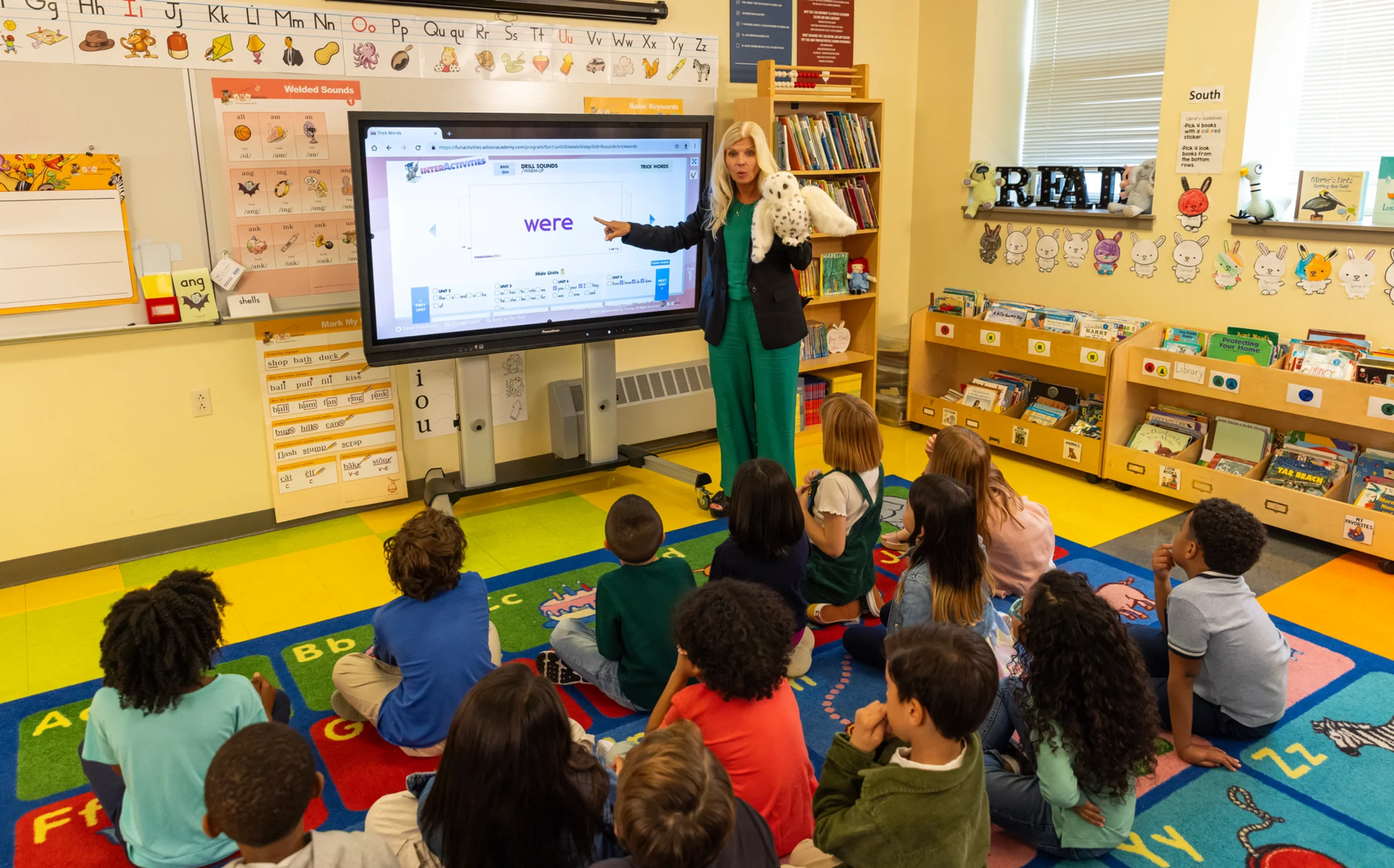 Teacher using interactive whiteboard for structured literacy lesson on "were