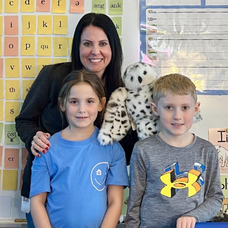 Teacher with two students and a stuffed owl in a classroom with sound cards