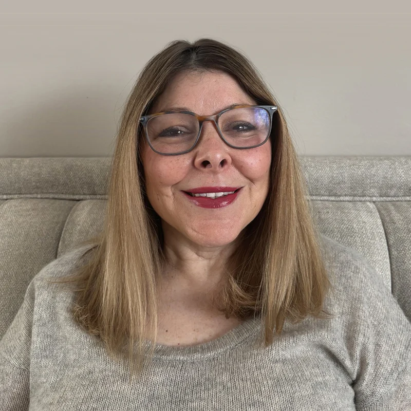 Woman with glasses and long blonde hair smiling